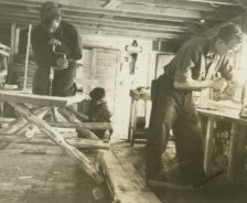 Four men making benches in a woodshop