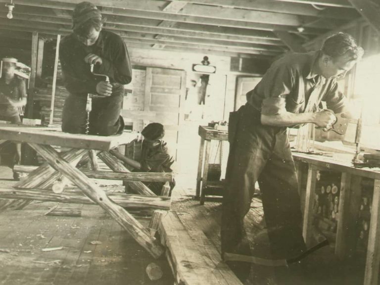 Four men making benches in a woodshop